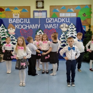 Uczniowie tańczą w kole z okazji Dnia Babci i Dziadka.  Kliknięcie na zdjęcie spowoduje jego powiększenie do rozmiaru oryginalnego.