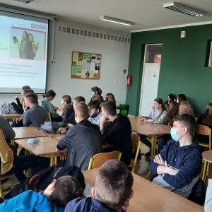 Mlodzież klasy 8 siedzi w ławkach. Uczestniczy w prelekcji dotyczącej wyboru przyszłego zawodu. Kliknięcie na zdjęcie spowoduje jego powiększenie do rozmiaru oryginalnego.