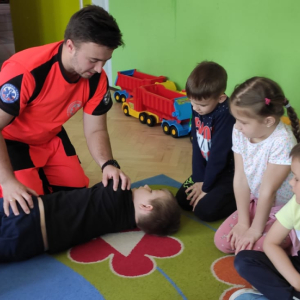 Przedszkolaki z oddziału przedszkolnego w Rudy Rysiu. Dzieci ćwiczą udzielanie pierwszej pomocy. Trenują pozycję boczną bezpieczną.  Klinięcie na zdjęcie spowoduje jego powiększenie do rozmiaru oryginalnego.