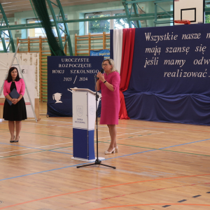 Przemówienie Pani Poseł Józefy Szczurek-Żelazko. W tle biało-niebieska dekoracja z biało-czerwoną flagą Polski. Goście ubrani w galowe stroje.  Kliknięcie na zdjęcie spowoduje jego powiększenie do rozmiaru oryginalnego