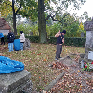 Uczniowie na Cmentarzu w Szczurowej sprzątają mogiły żołnierzy poległych w czasie I wojny światowej oraz zbiorowy grób Romów zamordowanych w czasie II wojny światowej. Dzieci ubrane w jesienne ubrania, grabią liście i wrzucają je do worków na śmieci. Kliknięcie na zdjęcie spowoduje jego powiększenie do rozmiaru oryginalnego.