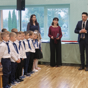 Wójt Gminy Szczurowa gratuluje uczniom kl. I występu. Dzieci wraz z nauczycielami stoją obok. Kliknięcie na zdjęcie spowoduje jego powiększenie do rozmiaru oryginalnego.