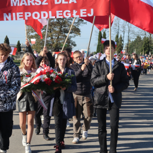 Uczniowie kl. 6b idą na czele uroczystego marszu z okazji Narodowego Święta Niepodległości. Chłopcy niosą biało-czerwony transparent z napisem "11 listopada Marsz dla Niepodległej" za nimi uczniowie kl. 4a,b niosą długą biało-czerwoną flagę oraz pozostali uczestnicy marszu. Kliknięcie na zdjęcie spowoduje jego powiększenie do rozmiaru oryginalnego.