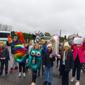 Uczniowie kl. 5 b wraz z wychowawcą na terenie Szczurowej egzaminują napotkane osoby z tabliczki mnożenia. Dzieci ubrane w kolorowe jesienne ubrania trzymają balony w kształcie cyfr. Kliknięcie na zdjęcie spowoduje jego  powiększenie do rozmiaru oryginalnego.