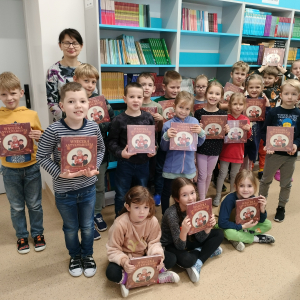 Bibliotekarka wręcza w szkolnej bibliotece pierwszoklasistom darmowe książki pani Justyny Bednarek przesłane przez Instytut Książki. Kliknięcie na zdjęcie spowoduje jego powiększenie do rozmiaru oryginalnego.