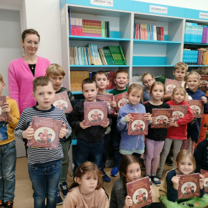 Bibliotekarka wręcza w szkolnej bibliotece pierwszoklasistom darmowe książki pani Justyny Bednarek przesłane przez Instytut Książki. Kliknięcie na zdjęcie spowoduje jego powiększenie do rozmiaru oryginalnego.