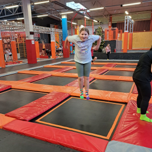 Dziewczynka podskakuje na trampolinie.  Kliknięcie na zdjęcie spowoduje jego powiększenie do rozmiaru oryginalnego.