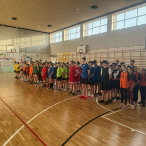 Reprezentanci szkół biorących udział w zawodach sportowych w Strzelcach Wielkich stoją razem na hali sportowej Szkoły Podstawowej w Strzelcach Wielkich. Kliknięcie na zdjęcie spowoduje jego powiększenie do rozmiaru oryginalnego.