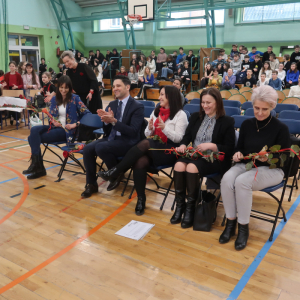 Wójt Gminy Zbigniew Moskal, Dyrektor Joanna Ozorka-Krawczyk, Wicedyrektor Dorota Gurgul oraz pracownicy Gminy panie: Teresa Sznajder oraz Elżbieta Gądek siedzą na hali w Zespole Szkół w Szczurowej. Oglądają występ z okazji Walentynek. Kliknięcie na zdjęcie spowoduje jego powiększenie do rozmiaru oryginalnego.