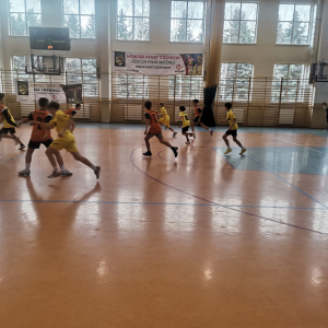 Przedstawiciele naszej szkoły biegają po hali. Młodzież gra z innymi zawodnikami w mini koszykówce. Kliknięcie na zdjęcie spowoduje jego powiększenie do rozmiaru oryginalnego.