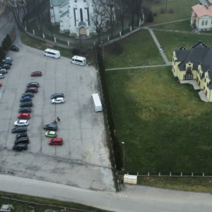 Zdjęcie parkingu w Szczurowej oraz szkoły, kościoła wykonane z drona. Z góry widać samochody budynek szkoły, fragment kościoła i domu parafialnego. Kliknięcie na zdjęcie spowoduje jego powiększenie do rozmiaru oryginalnego.
