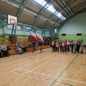 Uczniowie biegają z flagami Polski w rękach. Obok stoją pozostali, czekają na swoją kolej, aby biegiem upamiętnić Żołnierzy Wyklętych. Na trybunach siedzą nauczyciele. Kliknięcie na zdjęcie spowoduje jego powiększenie do rozmiaru oryginalnego.