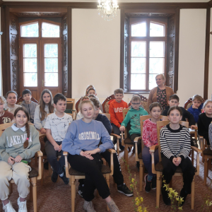 Autorka pani Irena Góra stoi wśród uczniów kl. 5, którzy siedzą na krzesłach. Obecni znajdują się w Bibliotece Publicznej w Szczurowej. Kliknięcie na zdjęcie spowoduje jego powiększenie do rozmiaru oryginalnego.