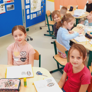 Dziewczynki uczestnicą w innowacji pedagogicznej na świetlicy szkolnej. Siedzą na krzesełkach i uśmiechają się. Kliknięcie na zdjęcie spowoduje jego powiększenie do rozmiaru oryginalnego.
