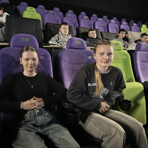 Uczestniczki wycieczki siedzą w kinie. Kliknięcie na zdjęcie spowoduje jego powiększenie do rozmiaru oryginalnego. 