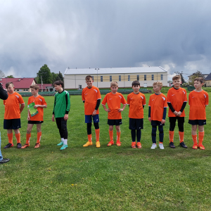 Reprezentanci naszej szkoły stoją ubrani w stroje sportowe na boisku w Tymbarku. Kliknięcie na zdjęcie spowoduje jego powiększenie do rozmiaru oryginalnego.