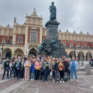 Uczestnicy wycieczki przed pomnikiem Adama Mickiewicza w Krakowie. W tle Sukiennice. Kliknięcie na zdjęcie spowoduje jego powiększenie do rozmiaru oryginalnego.
