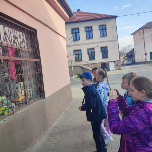 Dzieci z kl. 3 b fotografują aparatem cyfrowym budynki w Szczurowej.  Kliknięcie na zdjęcie spowoduje jego powiększenie do rozmiaru oryginalnego.