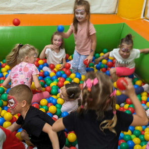 Przedszkolaki bawią się w basenie z kolorowymi piłkami na Dniu Dziecka. Kliknięcie na zdjęcie spowoduje jego powiększenie do rozmiaru oryginalego.