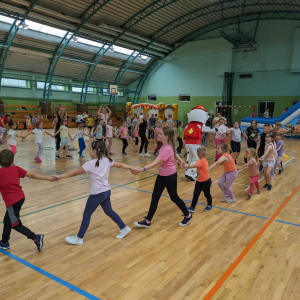 Przedszkolaki i uczniowie kl. 1-3 tańczą wraz z wychowawcami i animatorkami w czasie imprezy  z okazji Dnia Dziecka. Kliknięcie na zdjęcie spowoduje jego powiększenie do rozmiaru oryginalnego.