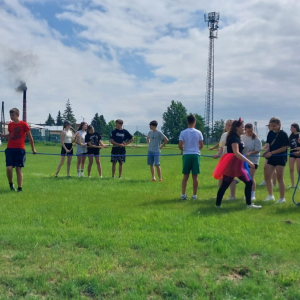 Uczniowie kl. 4-8  przeciągają linę w czasie obchodów Dnia Dziecka. Towarzyszy im pani animatorka. Kliknięcie na zdjęcie spowoduje jego powiększenie do rozmiaru oryginalnego.