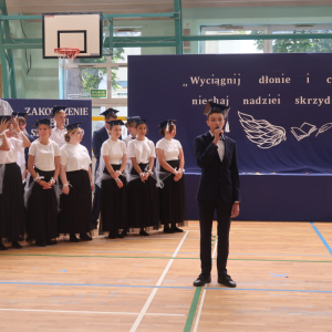 Bartłomiej Głąb wykonuje piosenkę, w tle pozostali absolwenci kl. 8.  Kliknięcie na zdjęcie spowoduje jego powiększenie do rozmiaru oryginalnego.