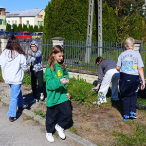 Uczniowie kl. 5 b zbierają śmieci z drogi w ramach akcji Sprzątanie Świata. Kliknięcie na zdjęcie spowoduje jego powiększenie do rozmiaru oryginalnego.