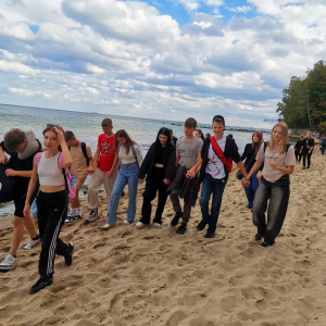 Uczniowie kl. 8 idą przez plażę w czasie wycieczki.  Kliknięcie na zdjęcie spowoduje jego powiększenie do rozmiaru oryginalnego.