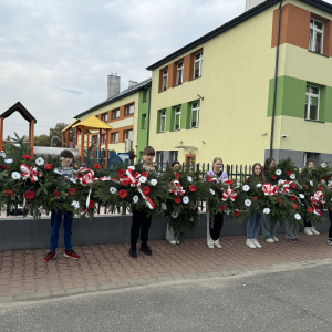 Uczniowie kl. 7 b trzymają wieńce przygotowane na mogiły poległych żołnierzy. Kliknięcie na zdjęcie spowoduje jego powiększenie do rozmiaru oryginalnego.