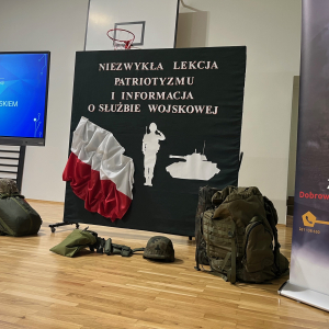 Dekoracja z sylwetką żołnierza, czołgiem i flagą oraz napisem "Niezwykła lekcja patriotyzmu" przygotowana na spotkanie z przedstawicielami Wojska Polskiego. Kliknięcie na zdjęcie spowoduje jego powiększenie do rozmiaru oryginalnego.