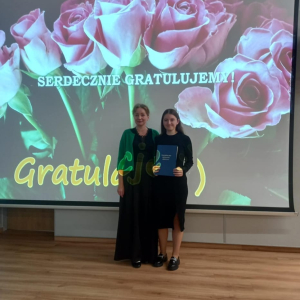 Uczennica Dorota Budzioch  - finalistka Małopolskiego Konkursu Języka Polskiego razem z panią Małgorzatą Tracz na rozdaniu nagród. W tle ekran z prezentacją zawierającą gratulacje. Kliknięcie na zdjęcie spowoduje jego powiększenie do rozmiaru oryginalnego.