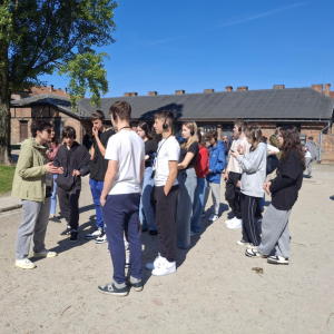 Ósmoklasiści wraz z przewodniczką zwiedzają teren obozu koncentracyjnego w Oświęcimiu. Kliknięcie na zdjęcie spowoduje jego powiększenie do rozmiaru oryginalnego.