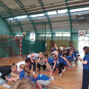 Rywalizacja rodziców i ich dzieci. Uczniowie klas 2 oraz ich rodzice biorą udział w zabawach sportowych przygotowanych przez wychowawczynie klas 2 z okazji obchodów Dnia Rodziny. Sekunduje im pani Dorota Gargul. Kliknięcie na zdjęcie spowoduje jego powiększenie do rozmiaru oryginalnego.