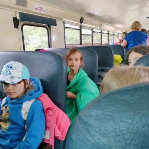 Dzieci siedzą w autobusie. Zwiedzają Zwierzyniec Górny. Oglądają przez okna zwierzęta. Kliknięcie na zdjęcie spowoduje jego powiększenie do rozmiaru oryginalnego.