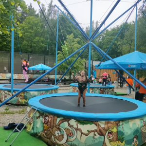 Jedna z dziewczynek ubrana w uprząż skacze na trampolinie w Bałtowie. Kliknięcie na zdjęcie spowoduje jego powiększenie do rozmiaru oryginalnego.