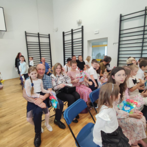 Rodzice uczniów klasy 1 a i b na sali gimnastycznej oczekują na występ swoich dzieci. Kliknięcie na zdjęcie spowoduje jego powiększenie do rozmiaru oryginalnego.