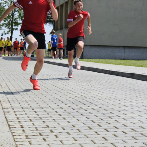 Chłopcy biegną w zawodach lekkoatletycznych. Kliknięcie na zdjęcie spowoduje jego powiększenie do rozmiaru oryginalnego.