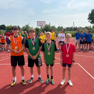 Czterech chłopców nagrodzonych medalami za osiągniecia w zawodach lekkoatletycznych. Kliknięcie na zdjęcie spowoduje jego powiększenie do rozmiaru oryginalnego.