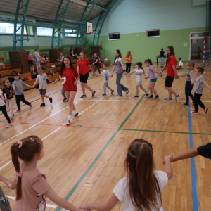 Dzieci tańczą z uczennicami klas 8 w trakcie obchodów Dnia Dziecka. Kliknięcie na zdjęcie spowoduje jego powiększenie do rozmiaru oryginalnego.
