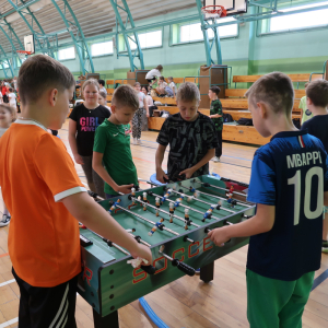 Chłopcy grają w piłkarzyki na hali sportowej w trakcie Dnia Dziecka. Kliknięcie na zdjęcie spowoduje jego powiększenie do rozmiaru oryginalnego.
