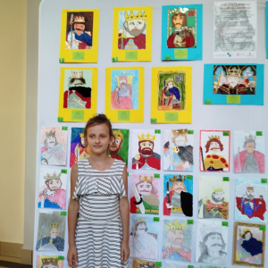 Karolina Nita z kl. 3 b na tle portretów Bolesława Chrobrego wykonanych w ramach konkursu. Kliknięcie na zdjęcie spowoduje jego powiększenie do rozmiaru oryginalnego.