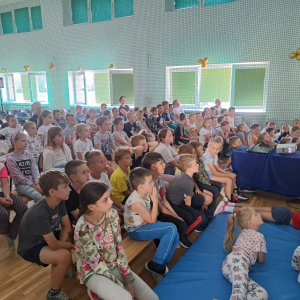 Uczniowie klas 1-3 zgromadzeni na spotkaniu z podróżnikiem na sali gimastycznej.  Kliknięcie na zdjęcie spowoduje jego powiększenie do rozmiaru oryginalnego.