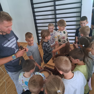 Pan podróżnik pokazuje przedszkolakom i dzieciom pamiątki przywiezione z podróży do Afryki. Kliknięcie na zdjęcie spowoduje jego powiększenie do rozmiaru oryginalnego.