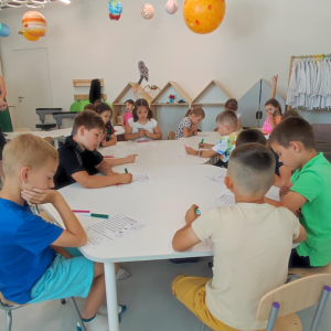 Pierwszoklasiści siedzą przy stolikach i rysują na zajęciach w Centrum Cogiteon w Krakowie. Kliknięcie na zdjęcie spowoduje jego powiększenie do rozmiaru oryginalnego.
