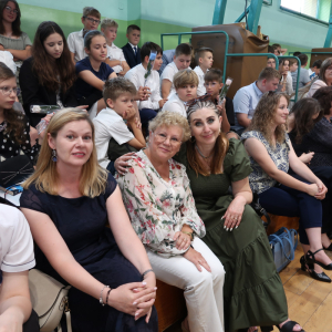 Panie Beata Stępak, Lucyna Gut i Hałyna Seńczyk na zakończniu roku szkonego. W tle uczniowie i rodzice.  Kliknięcie na zdjęcie spowoduje jego powiększenie do rozmiaru oryginalnego.