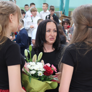 Wręczanie kwiatów pani Dyrektor Joannie Ozorce Krawczyk przez absolwentki klas 8.  Kliknięcie na zdjęcie spowoduje jego powiększenie do rozmiaru oryginalnego.