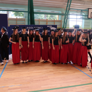 Absolwenci klas 8 ubrani w granatowe czapki absolwenta.  Kliknięcie na zdjęcie spowoduje jego powiększenie do rozmiaru oryginalnego.