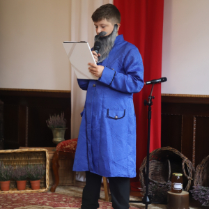 Uczeń przebrany za szlachcica czyta poezję Jana Kochanowskiego. Źródło zdjęć: GCKCziS Szczurowa. Kliknięcie na zdjęcie spowoduje jego powiększenie do rozmiaru oryginalnego.