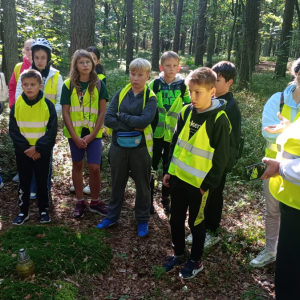 Uczniowie kl. 6 a i b ubrani w kamizelki odblaskowe na wycieczce integracyjnej w lesie w towarzystwie pani Ewy Borowiec. Kliknięcie na zdjęcie spowoduje jego powiększenie do rozmiaru oryginalnego.