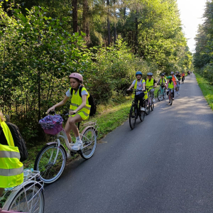 Uczniowie klas 5 jadą po drodze na rowerach. Kliknięcie na zdjęcie spowoduje jego powiększenie do rozmiaru oryginalnego.